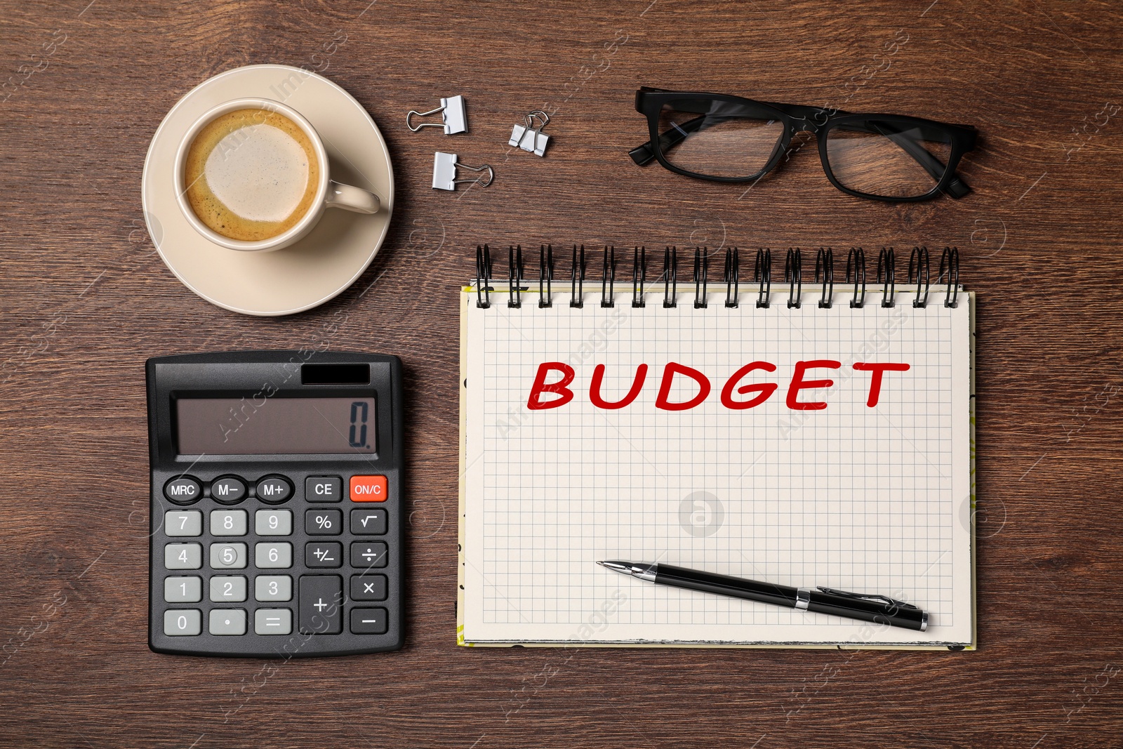 Image of Notebook with word Budget, calculator, glasses and coffee on wooden table, flat lay