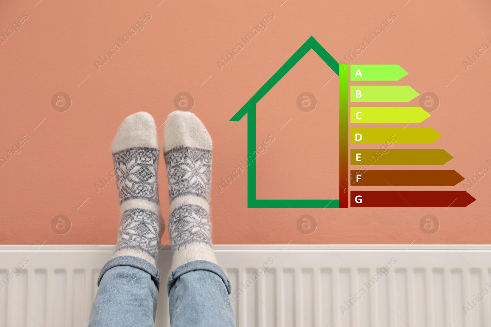 Image of Energy efficiency rating label on color wall and woman warming legs on heating radiator