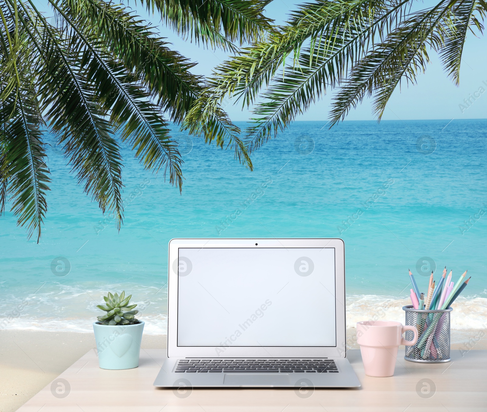 Image of Workplace at beach, distant office. Table with laptop on sandy seashore. Mockup for design