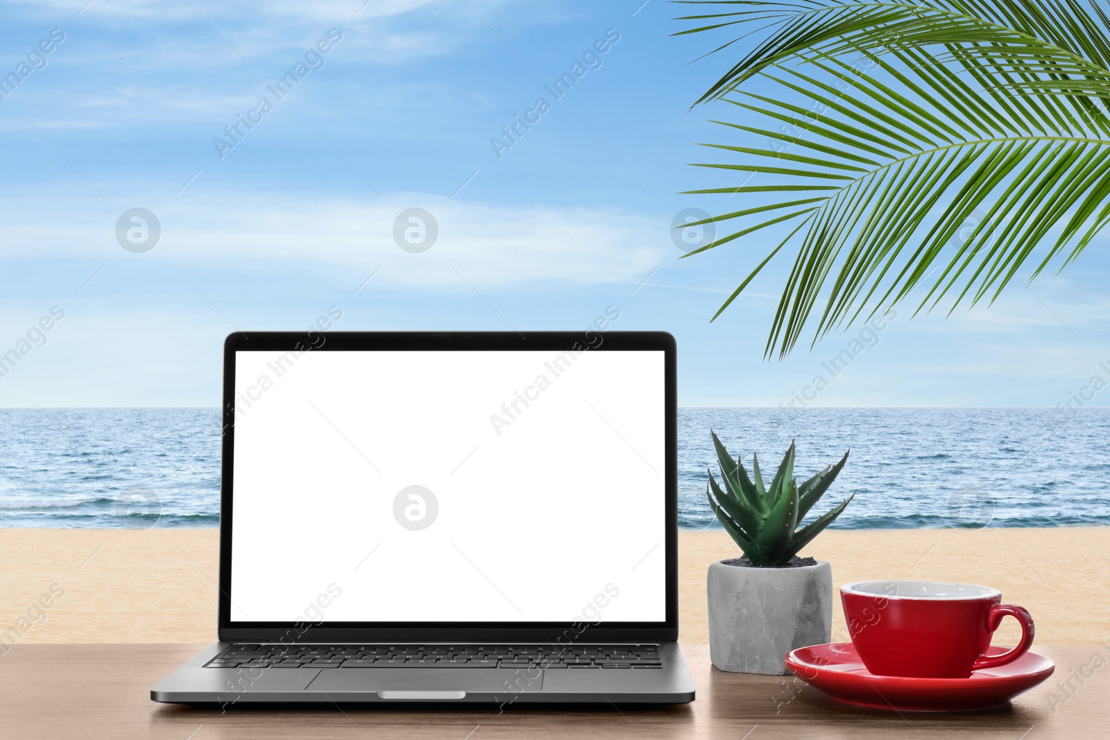 Image of Workplace at beach, distant office. Table with laptop on sandy seashore. Mockup for design