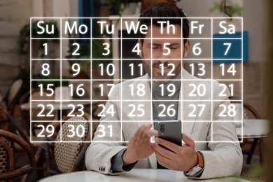 Image of Making timetable. Man using smartphone at table. Virtual calendar projected from device