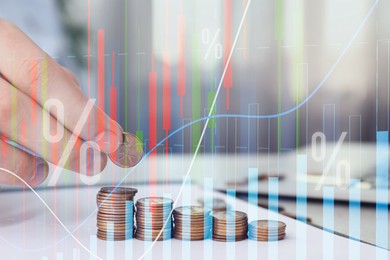 Image of Budget concept. Graphs and man stacking coins at table, double exposure