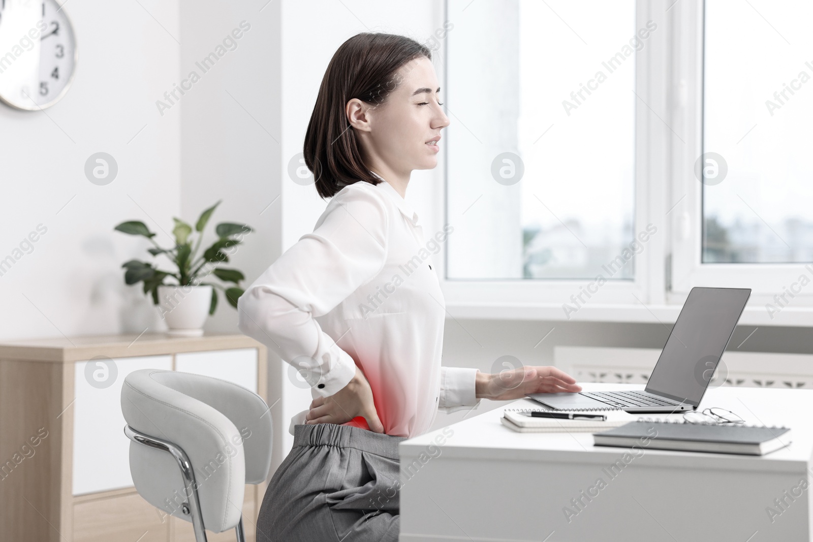 Image of Woman suffering from backache due to poor posture at workplace