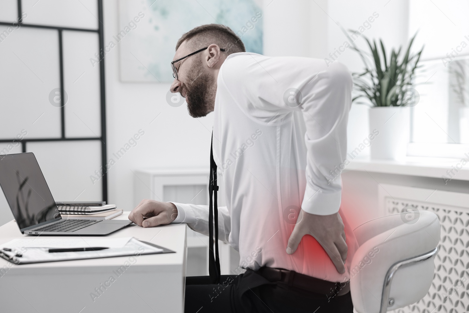 Image of Man suffering from backache due to poor posture at workplace