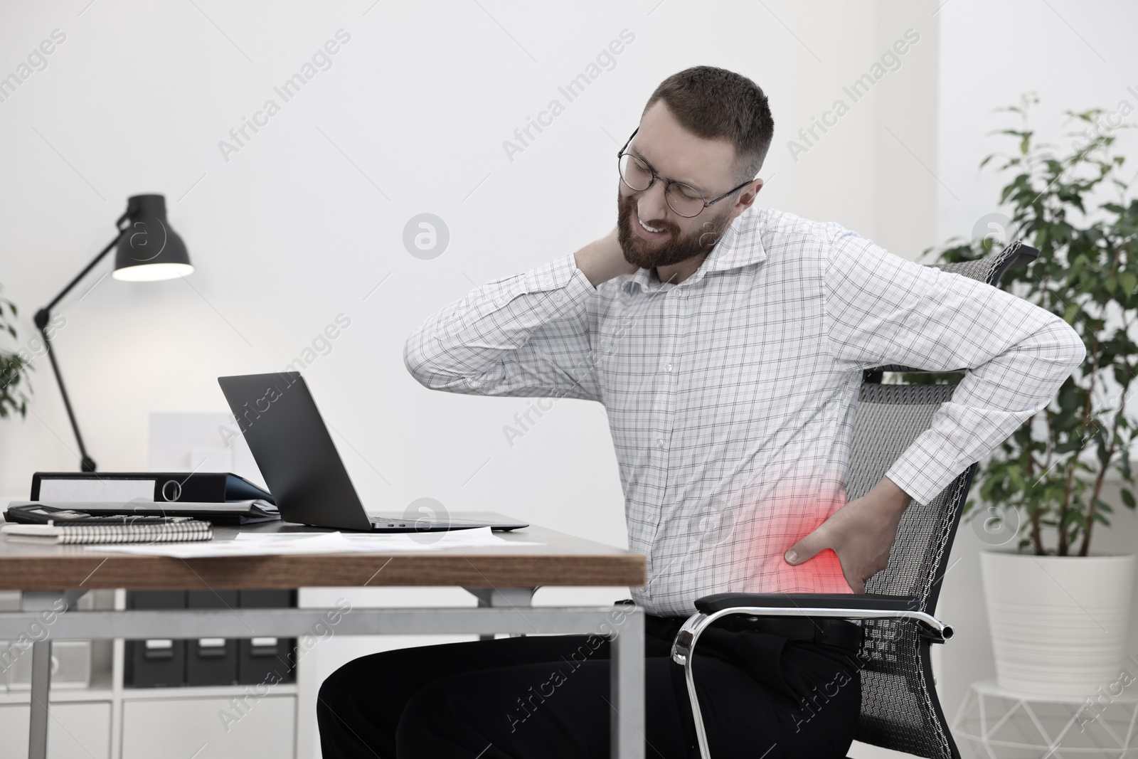 Image of Man suffering from backache due to poor posture at workplace