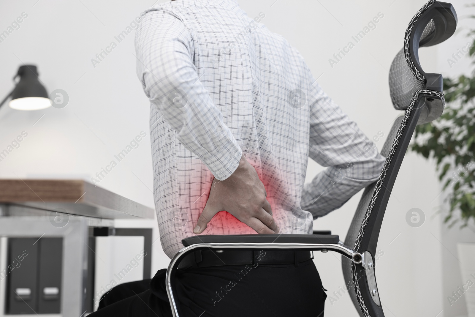 Image of Man suffering from backache due to poor posture at workplace