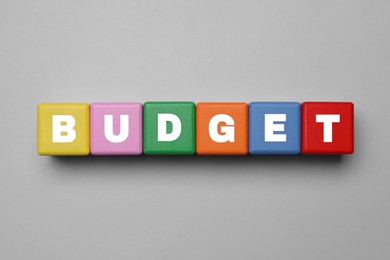 Image of Word Budget made of colorful cubes with letters on grey background, top view