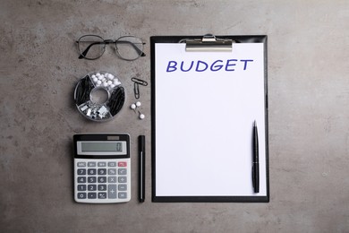 Image of Word Budget on paper, calculator and glasses on grey table, flat lay