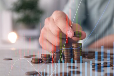 Budget concept. Graphs and man stacking coins at table, double exposure