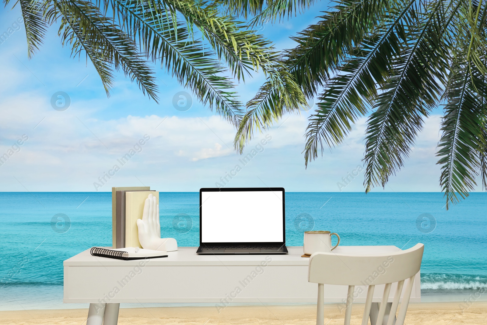 Image of Workplace at beach, distant office. Table with laptop and chair on sandy seashore. Mockup for design