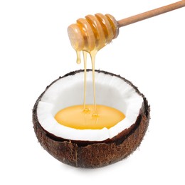 Image of Honey dripping from wooden dipper into coconut isolated on white