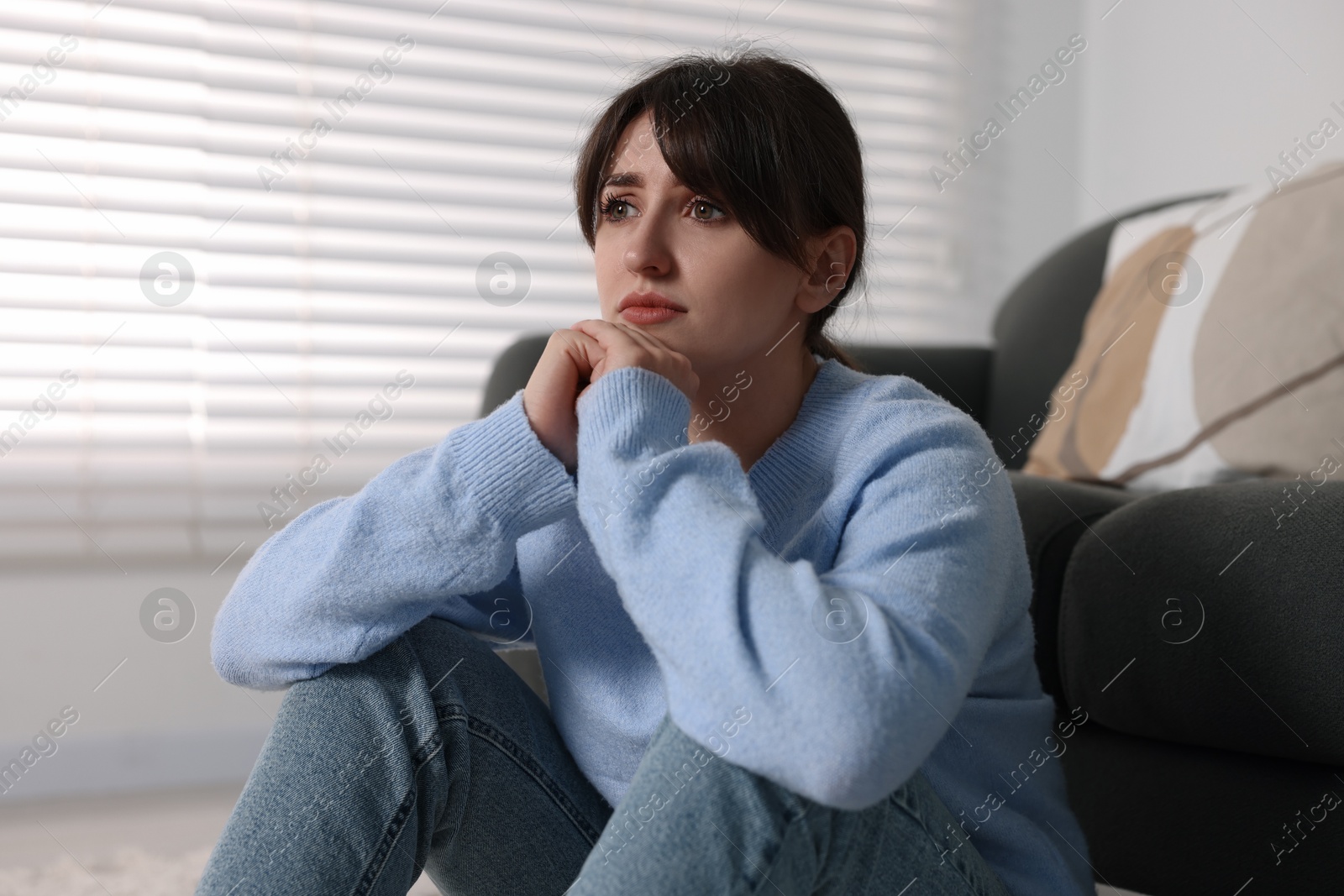 Photo of Loneliness concept. Sad woman sitting on floor at home