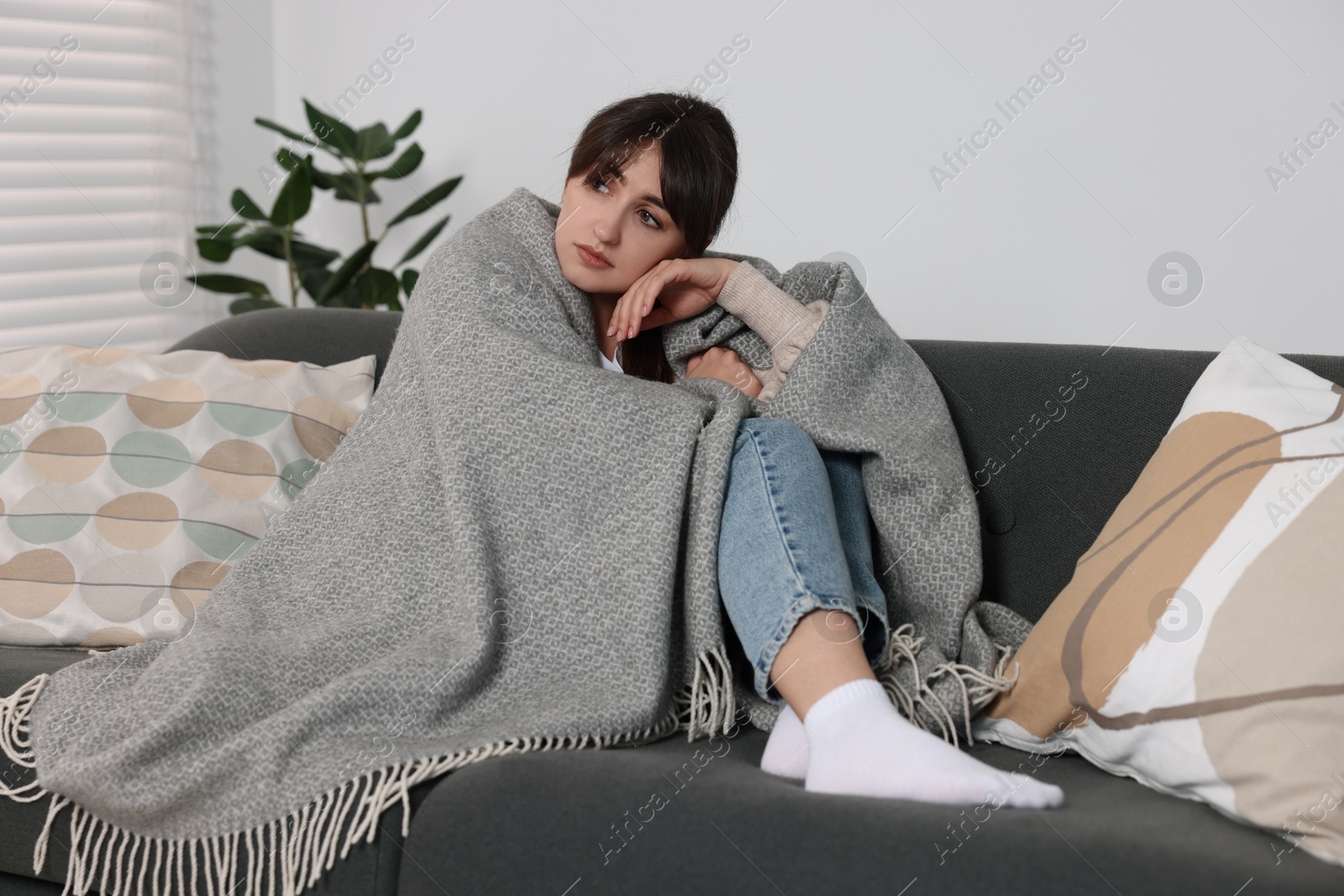 Photo of Loneliness concept. Sad woman sitting on sofa at home