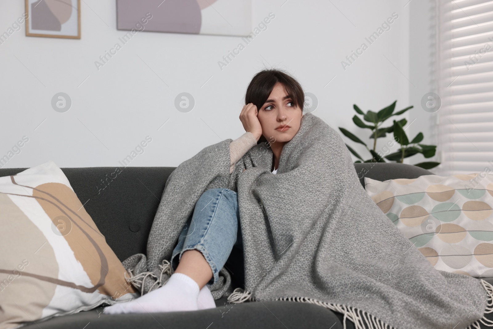 Photo of Loneliness concept. Sad woman sitting on sofa at home