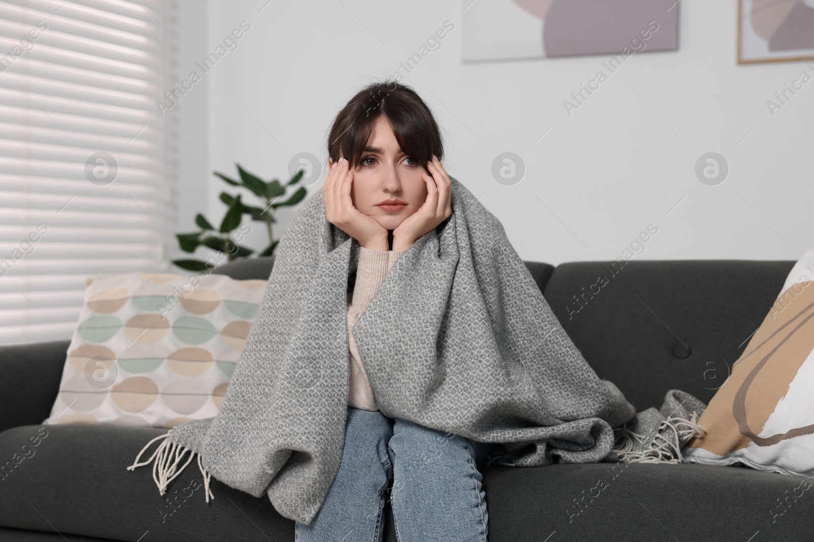 Photo of Loneliness concept. Sad woman sitting on sofa at home