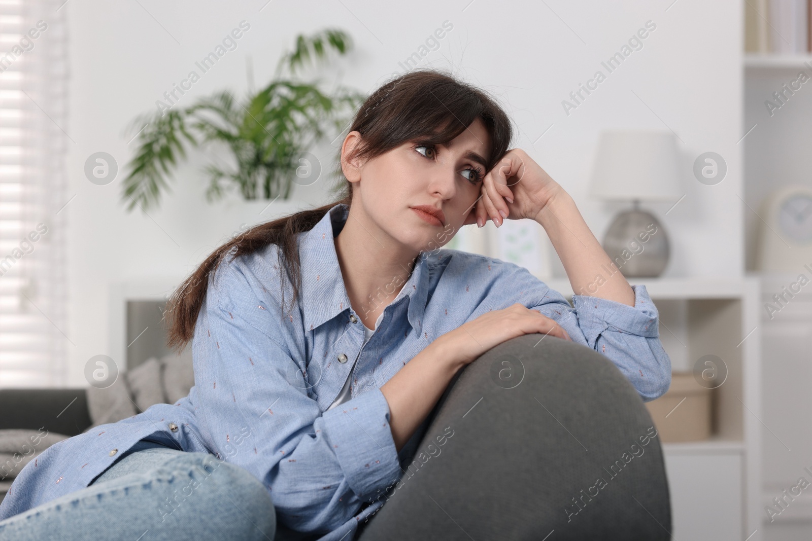 Photo of Loneliness concept. Sad woman sitting on sofa at home