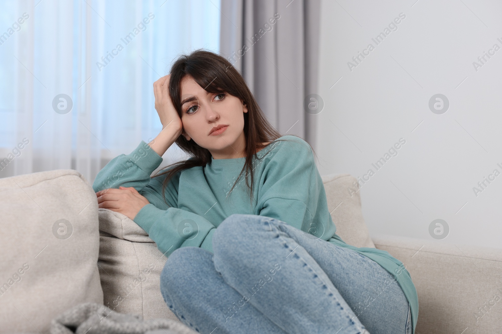 Photo of Loneliness concept. Sad woman sitting on sofa at home