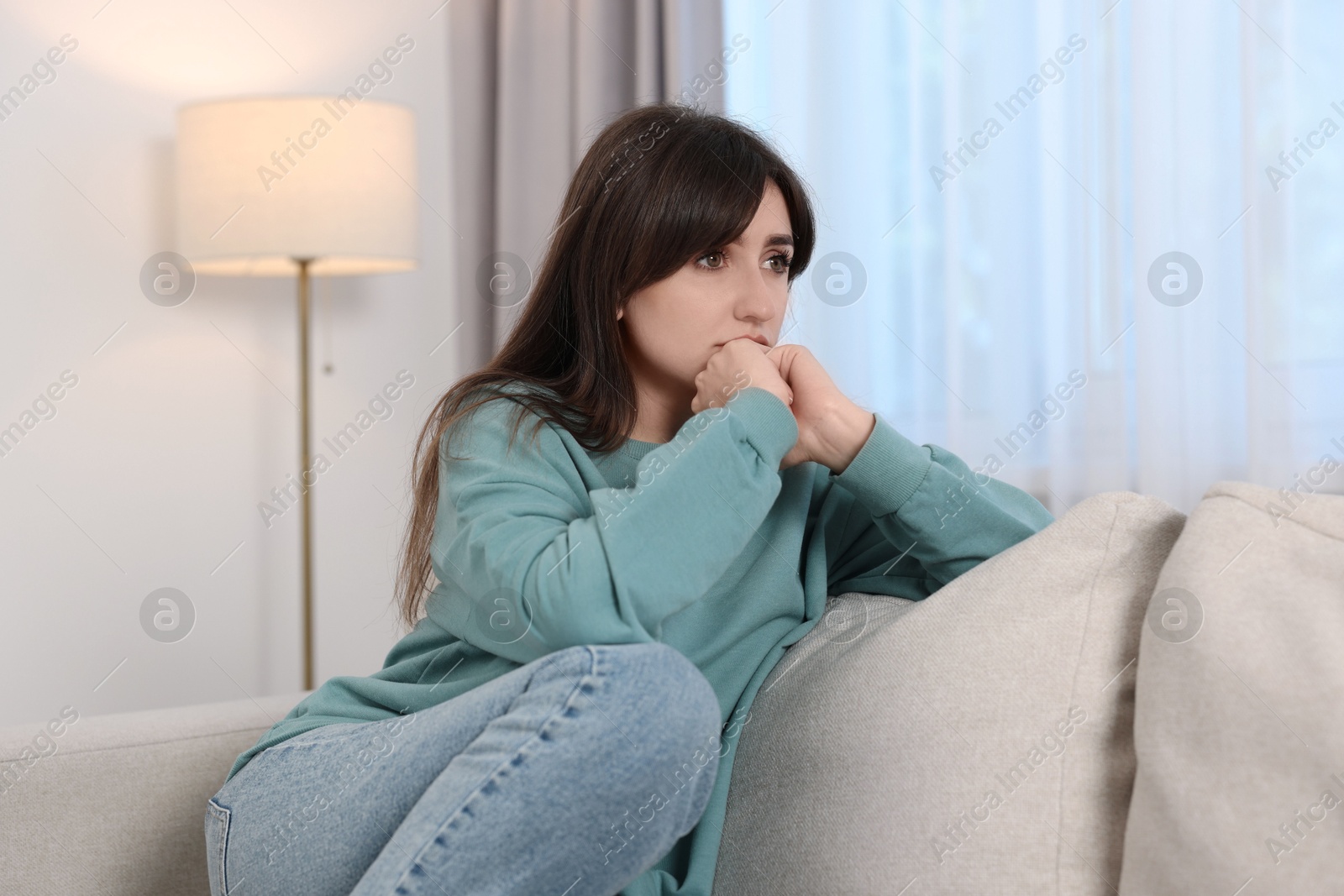 Photo of Loneliness concept. Sad woman sitting on sofa at home