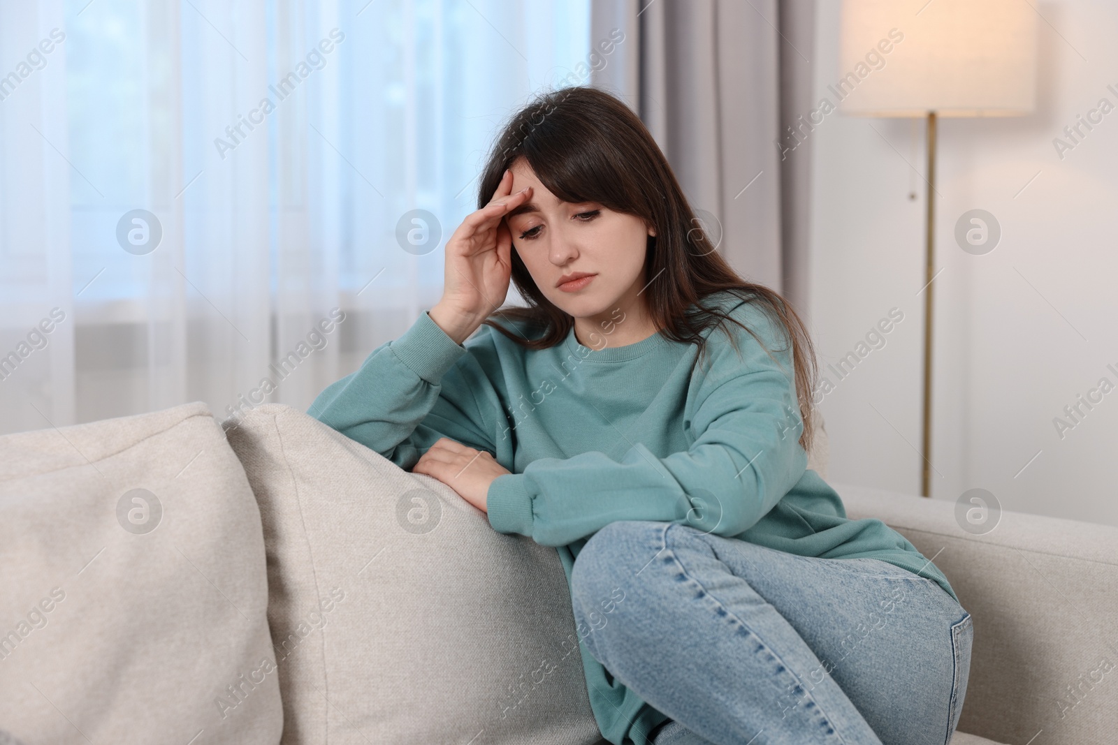 Photo of Loneliness concept. Sad woman sitting on sofa at home