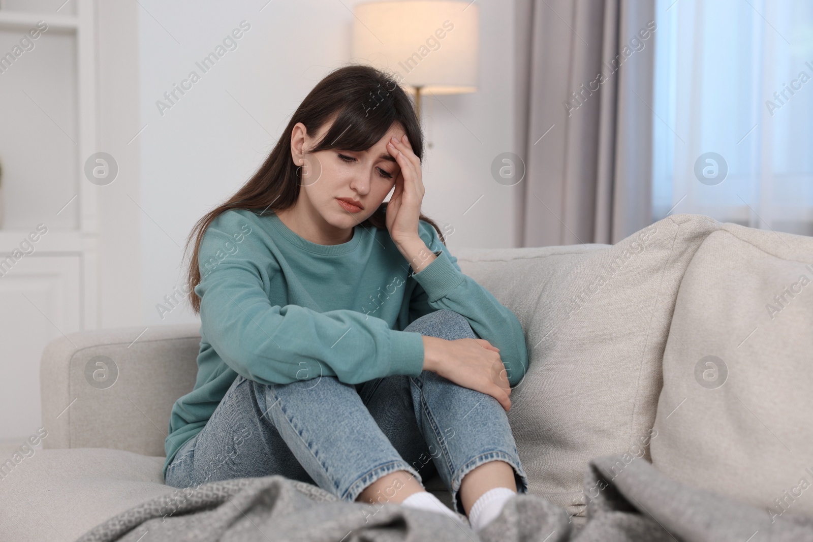 Photo of Loneliness concept. Sad woman sitting on sofa at home