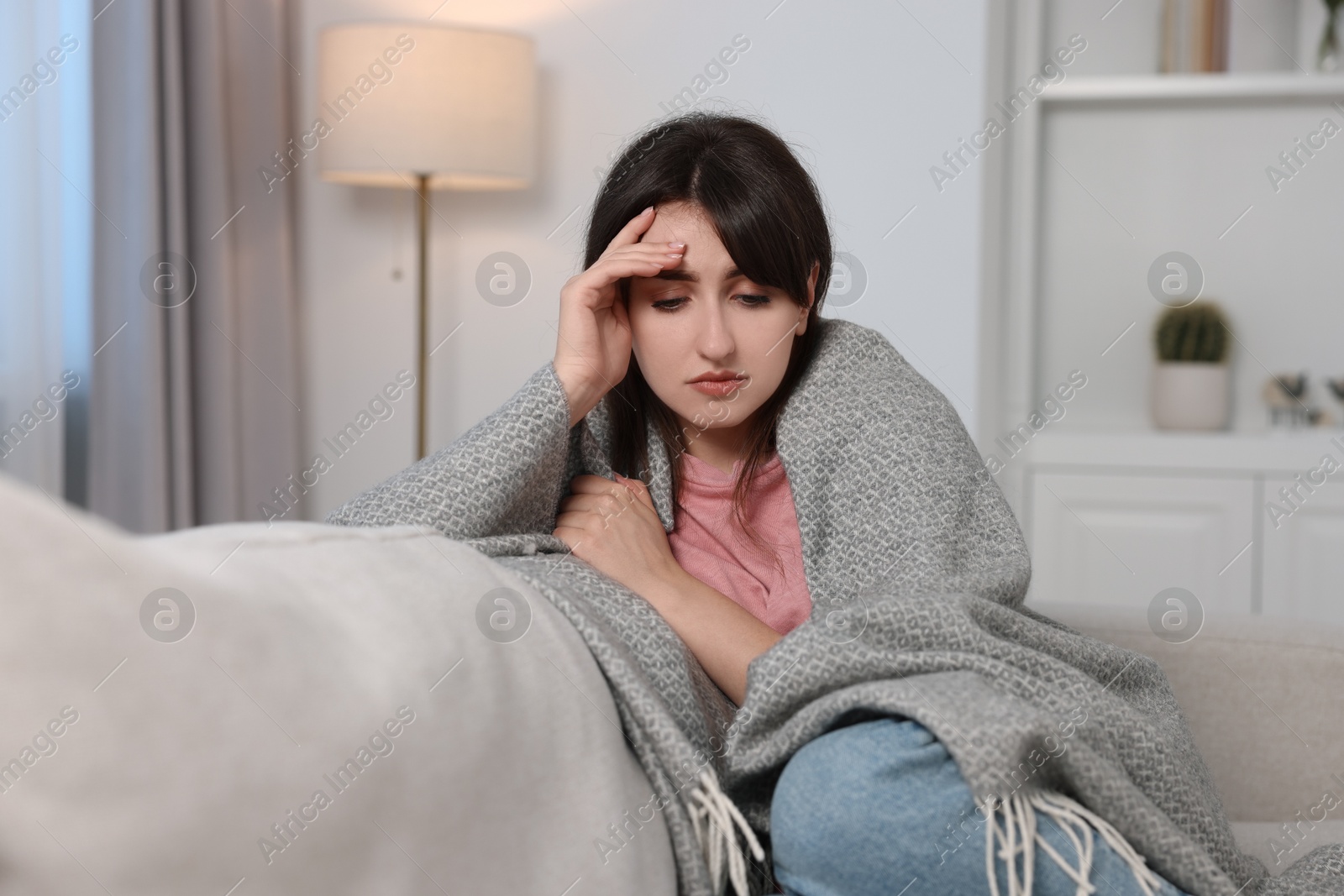 Photo of Loneliness concept. Sad woman sitting on sofa at home