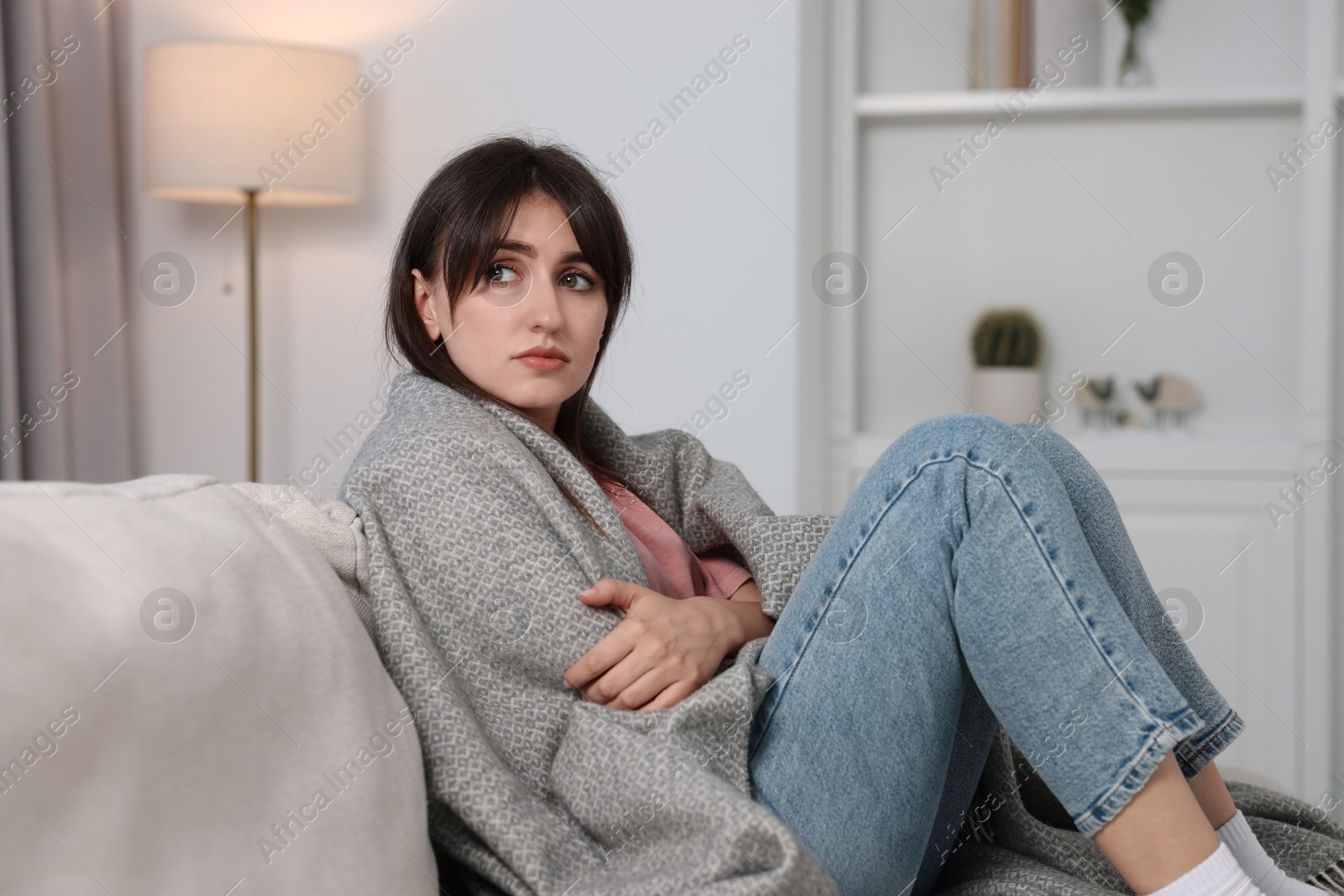 Photo of Loneliness concept. Sad woman sitting on sofa at home