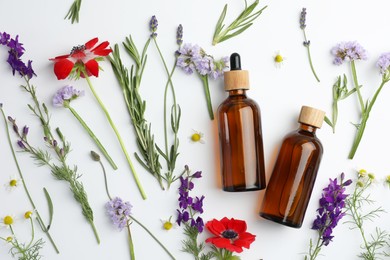 Photo of Aromatherapy. Essential oils, flowers and rosemary on white background, flat lay