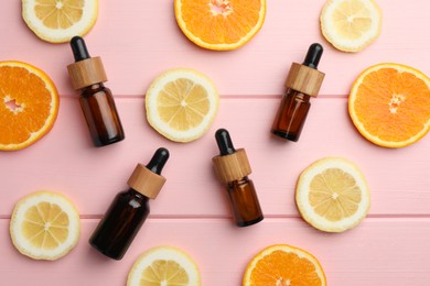 Photo of Aromatherapy. Different essential oils and citrus fruits on pink wooden table, flat lay