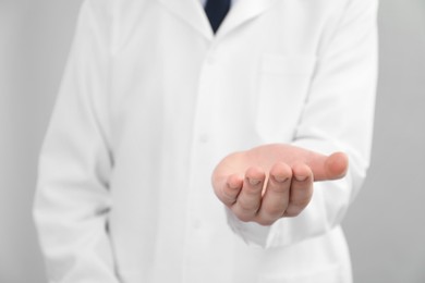 Photo of Doctor holding something on grey background, selective focus