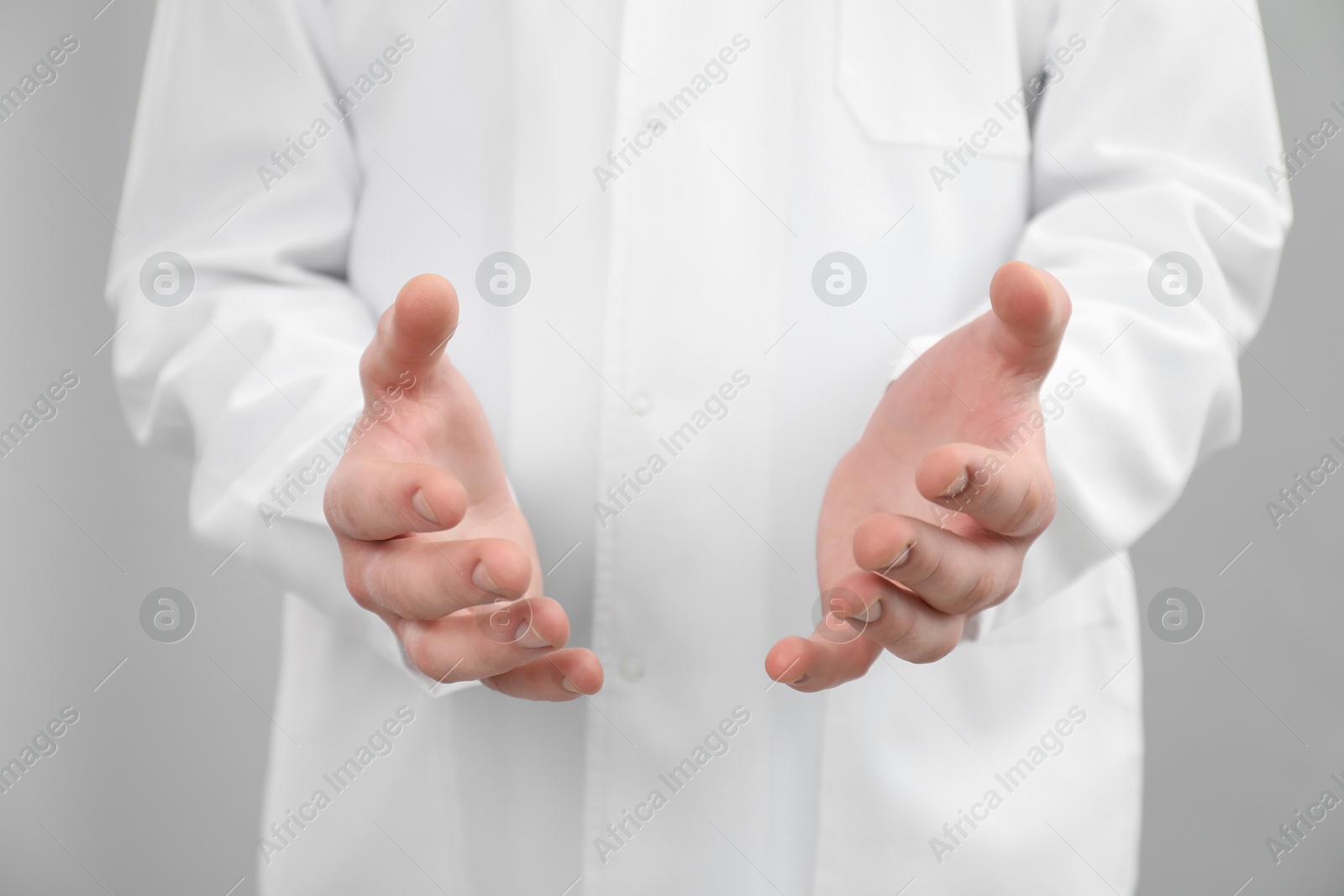 Photo of Doctor holding something on grey background, selective focus