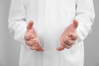 Photo of Doctor holding something on grey background, selective focus