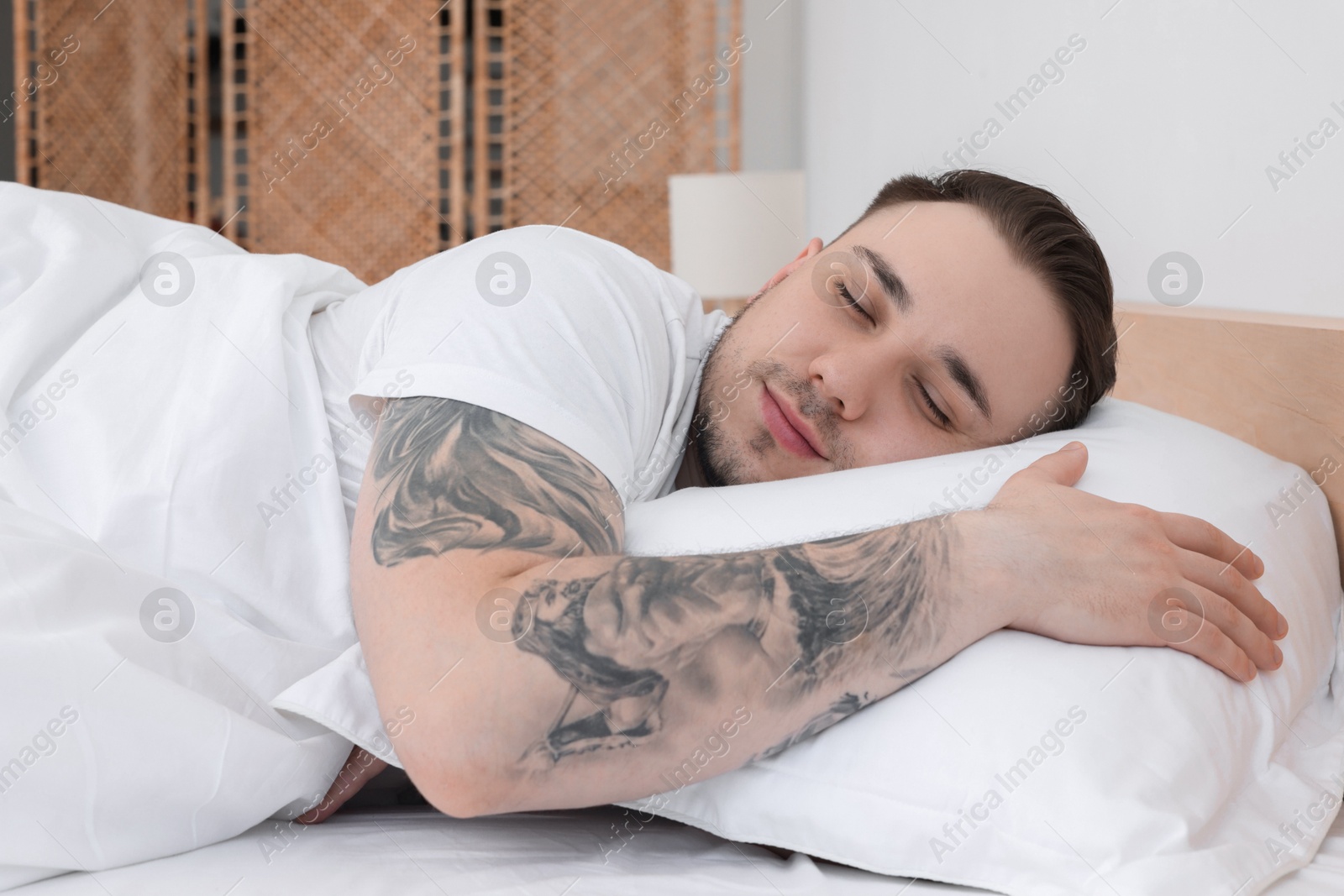 Photo of Bedtime. Handsome man sleeping in bed indoors