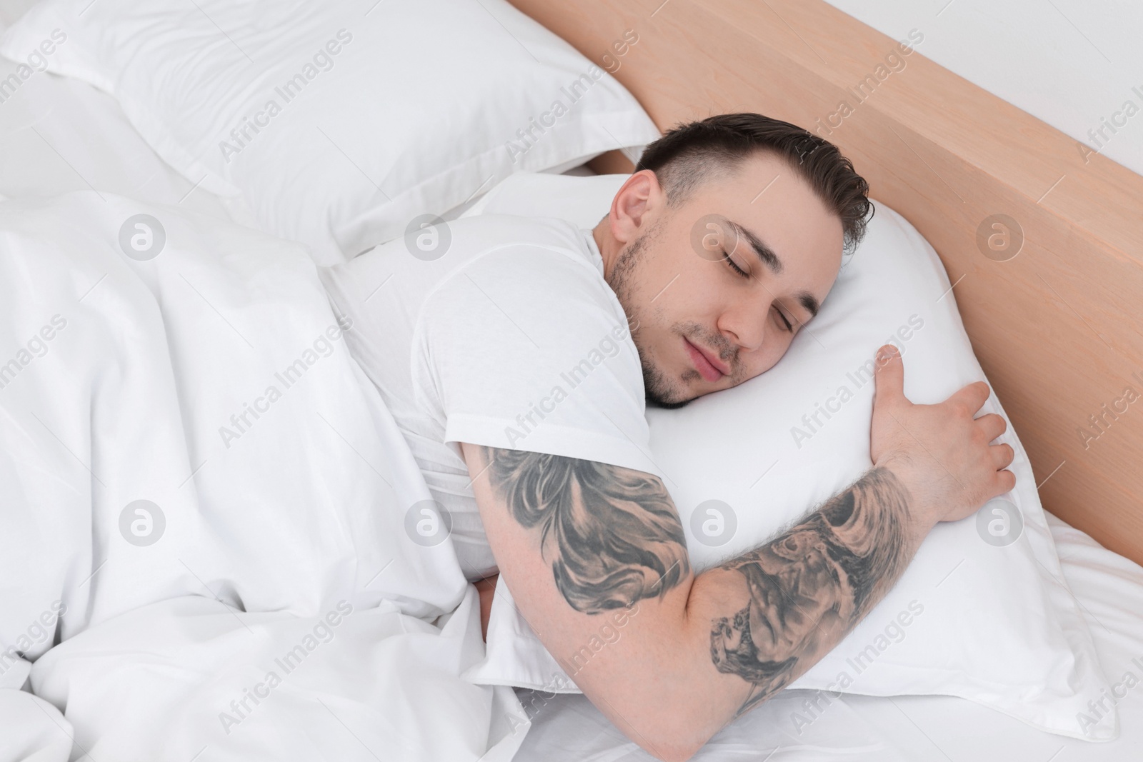 Photo of Bedtime. Handsome man sleeping in bed indoors