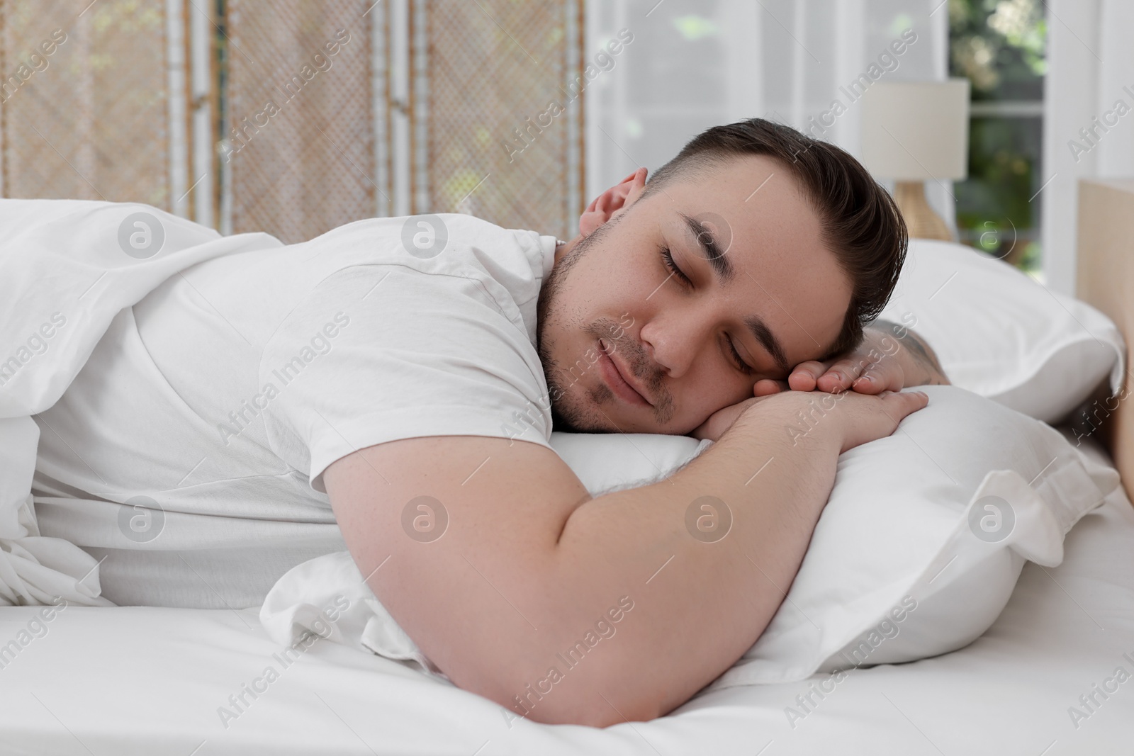 Photo of Bedtime. Handsome man sleeping in bed indoors