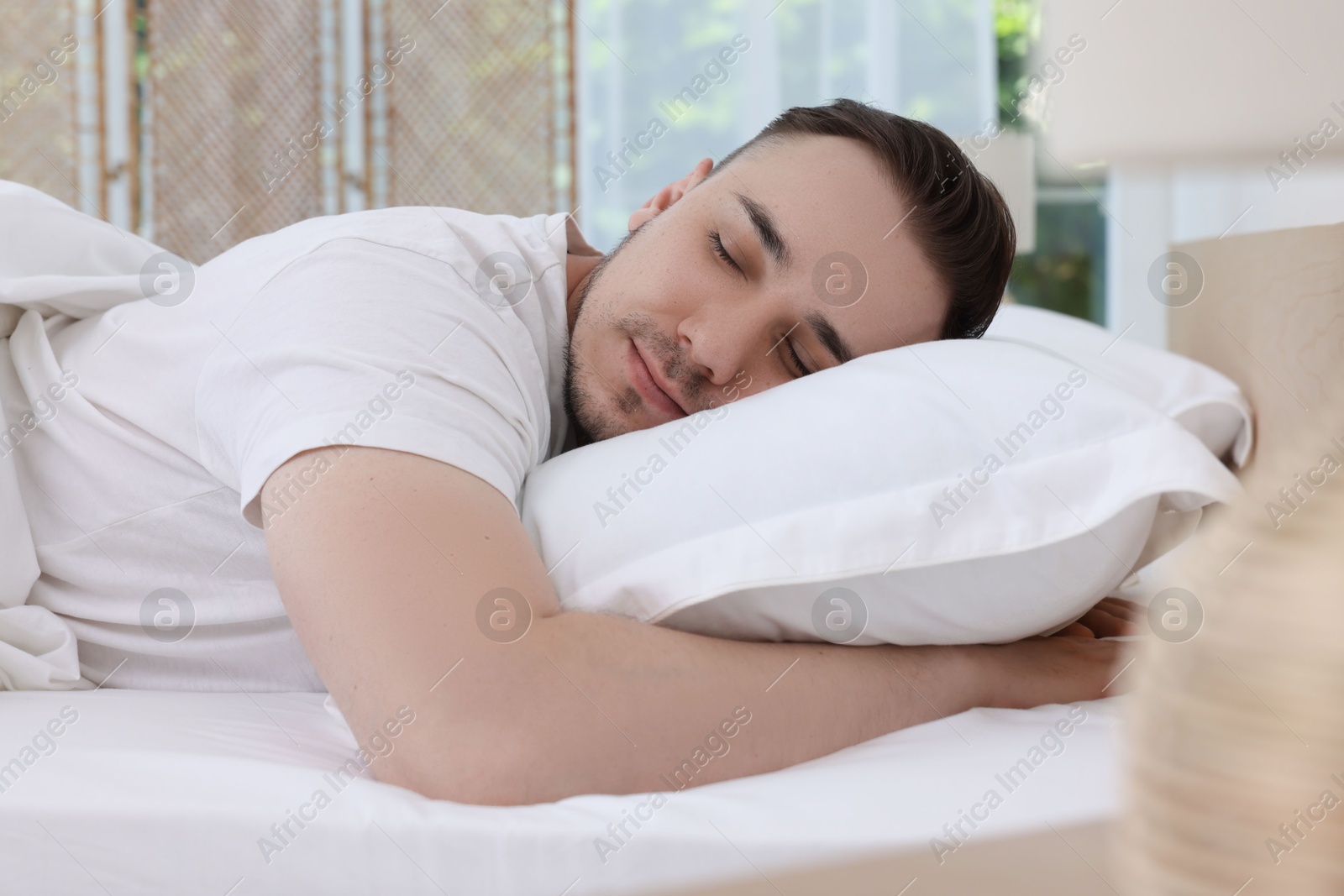 Photo of Bedtime. Handsome man sleeping in bed indoors