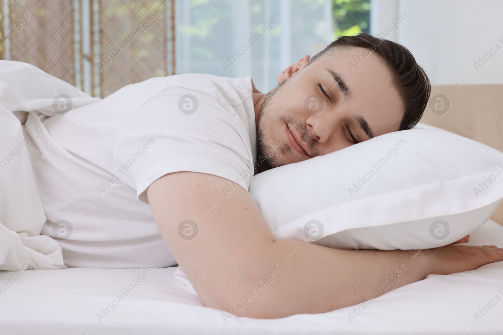 Photo of Bedtime. Handsome man sleeping in bed indoors