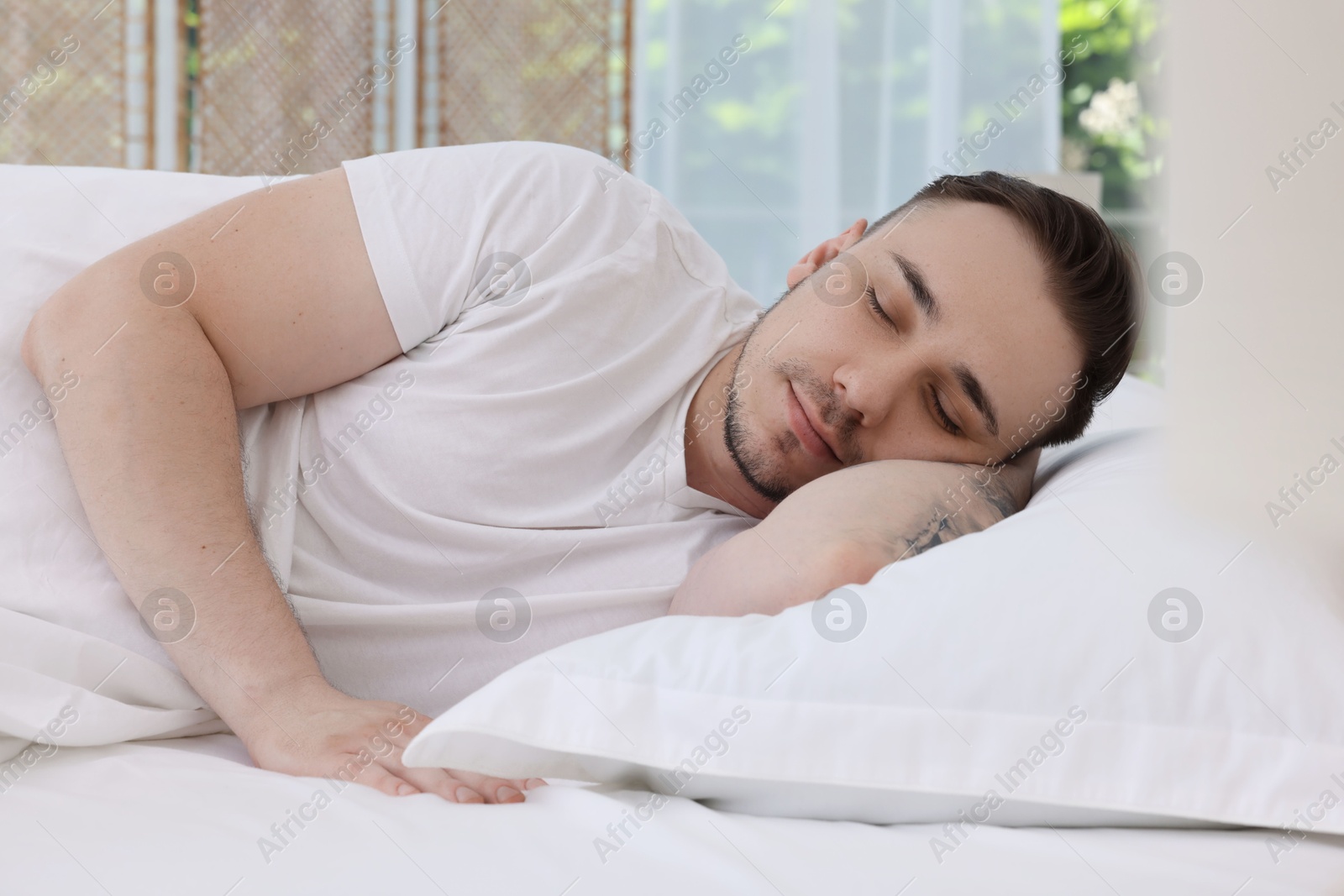 Photo of Bedtime. Handsome man sleeping in bed indoors