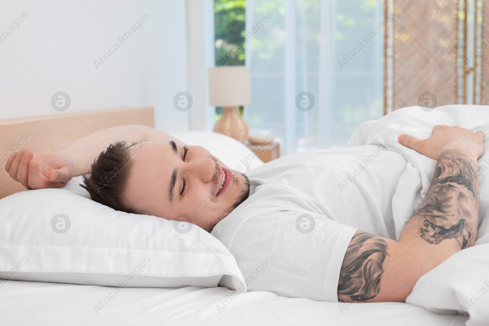 Photo of Bedtime. Handsome man sleeping in bed indoors