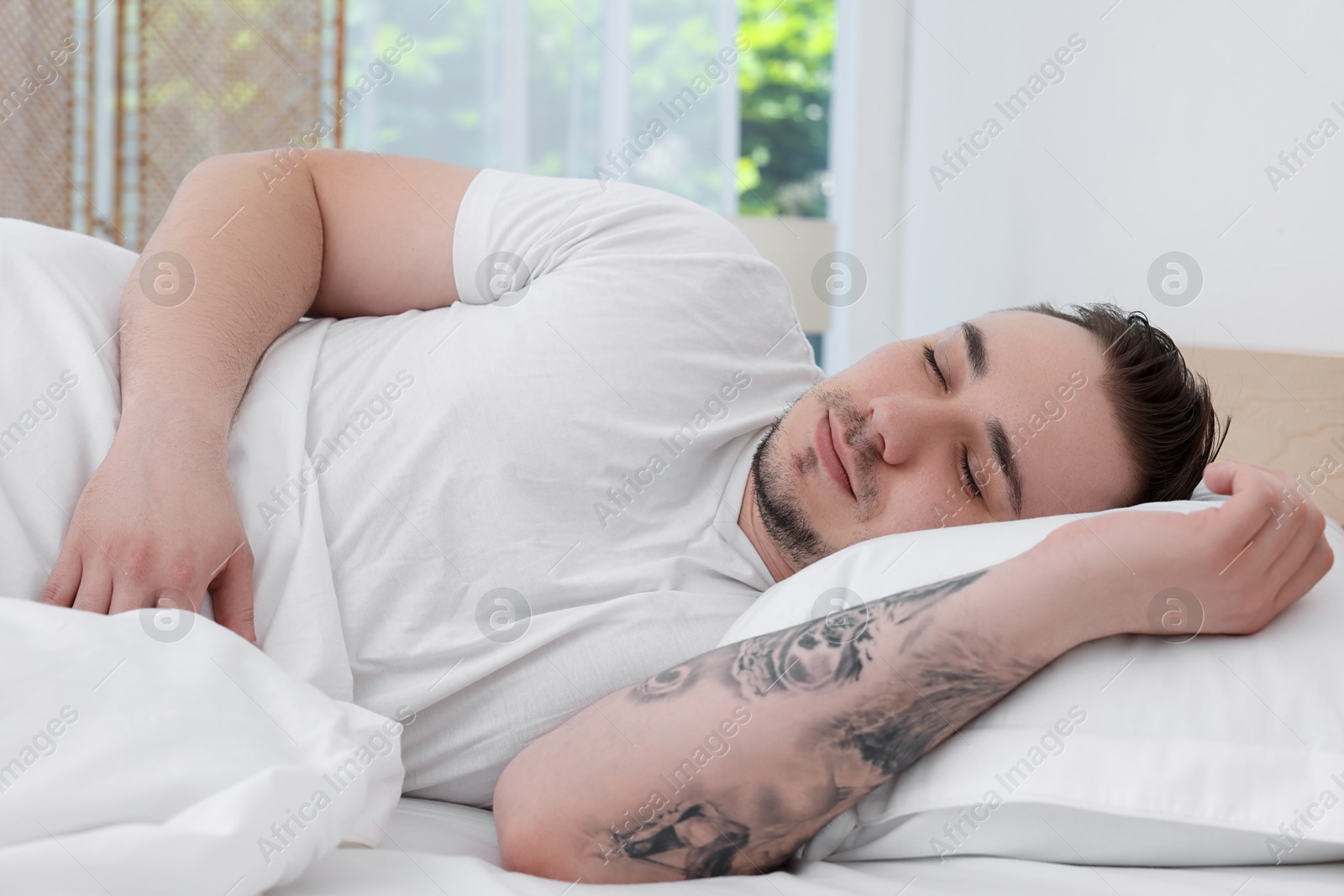 Photo of Bedtime. Handsome man sleeping in bed indoors