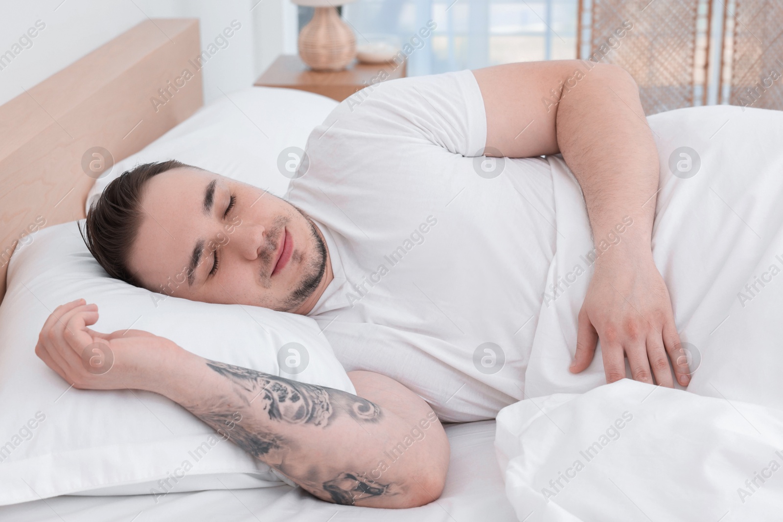 Photo of Bedtime. Handsome man sleeping in bed indoors