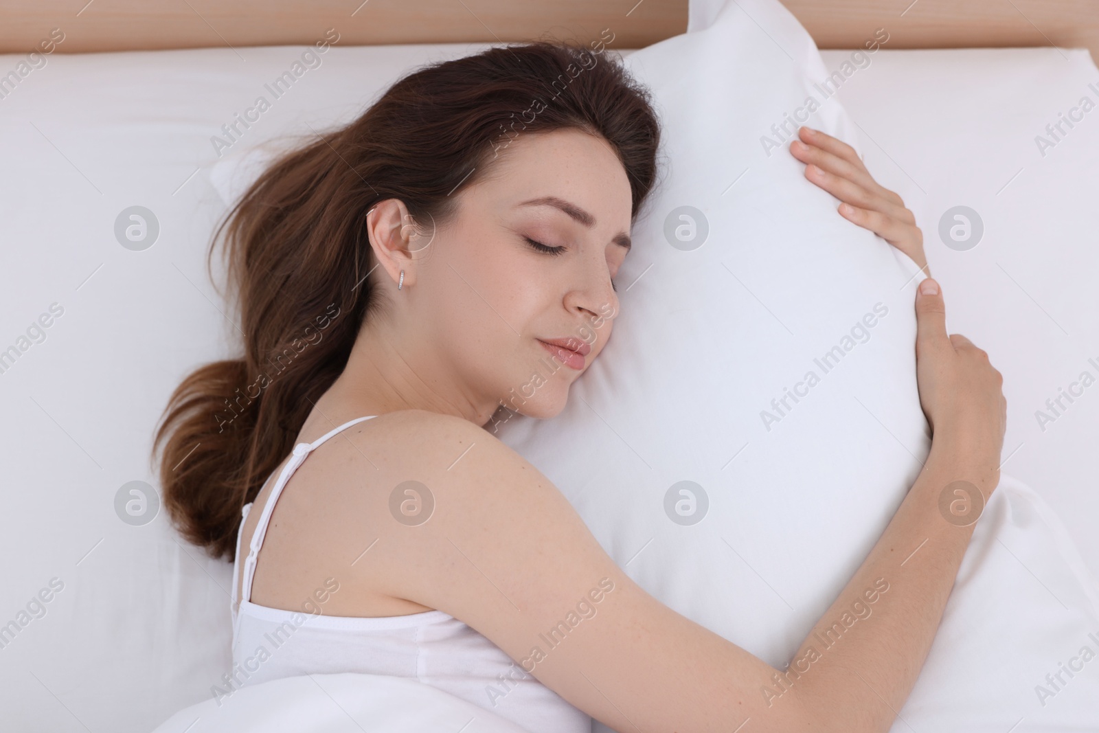 Photo of Bedtime. Woman sleeping in bed at home, above view