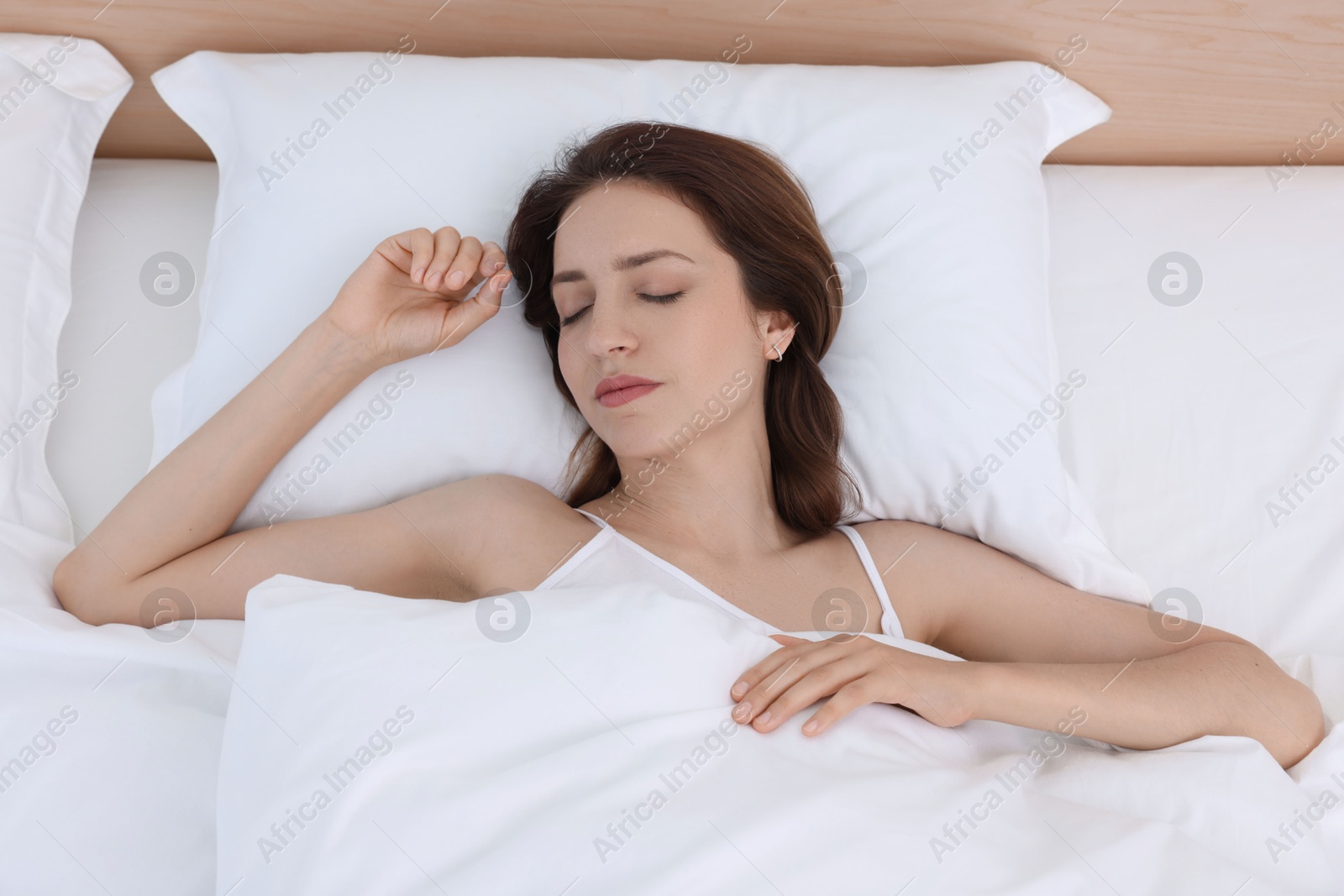 Photo of Bedtime. Woman sleeping in bed at home, top view