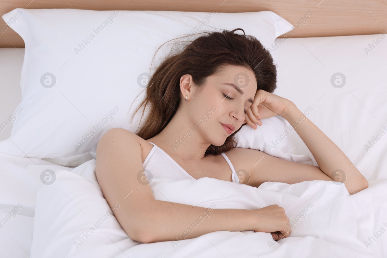 Photo of Bedtime. Woman sleeping in bed at home, top view