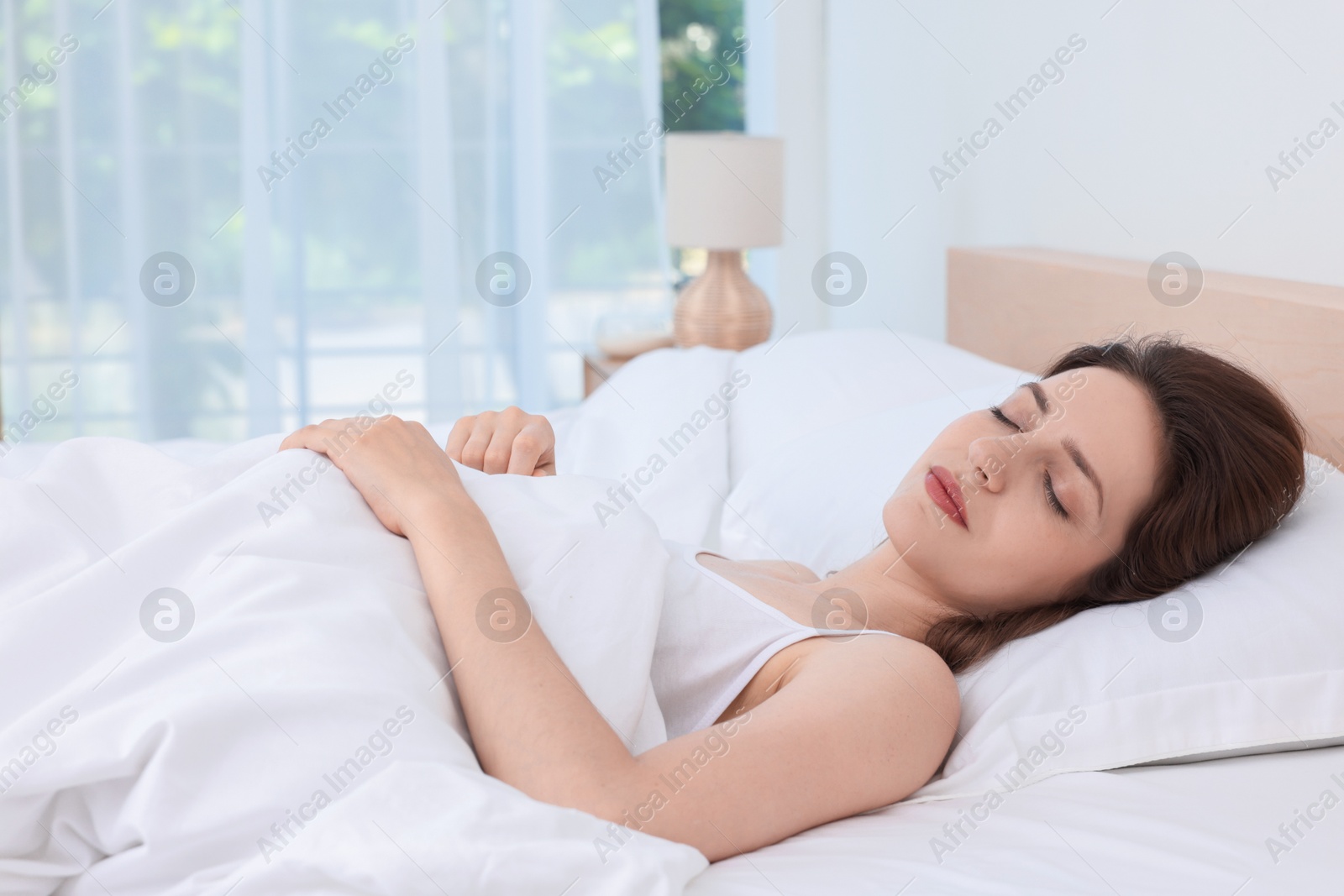 Photo of Bedtime. Woman sleeping in bed at home