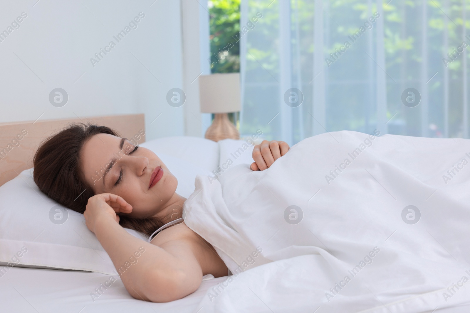 Photo of Bedtime. Woman sleeping in bed at home