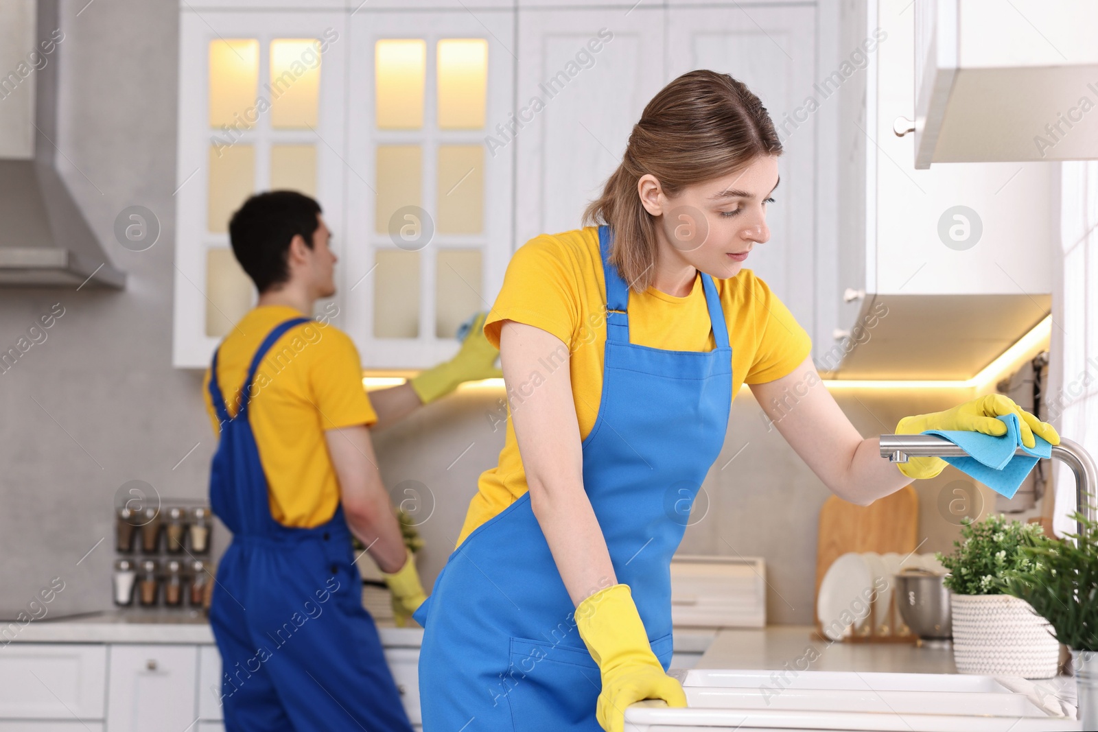 Photo of Professional janitors working in kitchen. Cleaning service