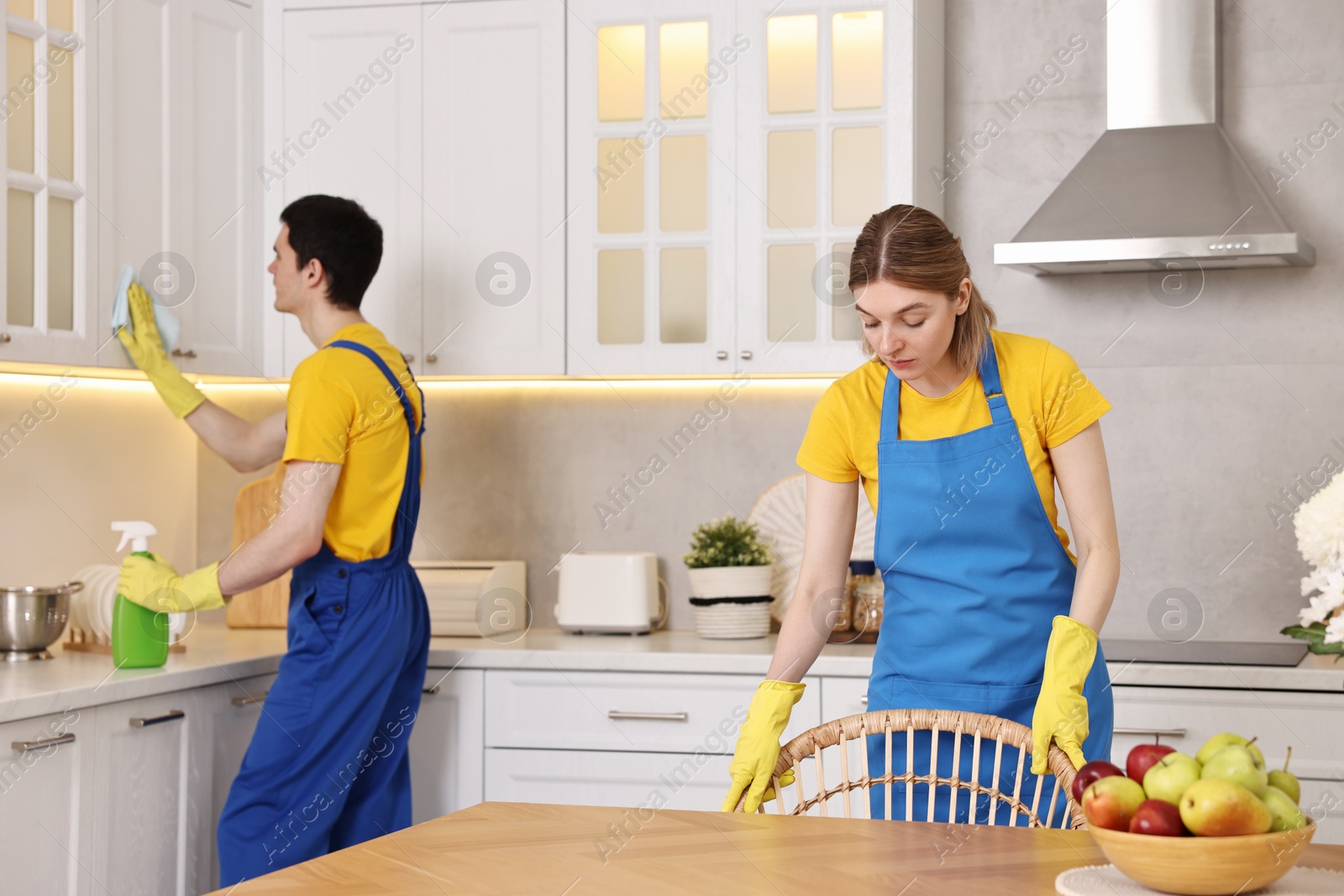 Photo of Professional janitors working in kitchen. Cleaning service