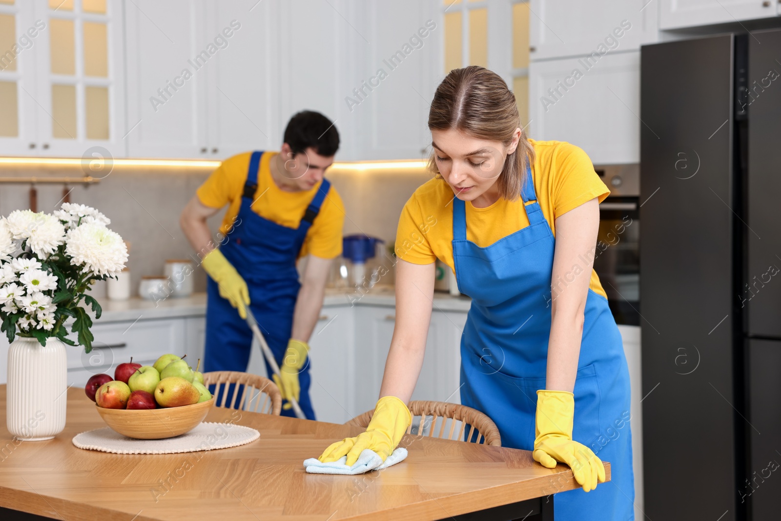 Photo of Professional janitors working in kitchen. Cleaning service