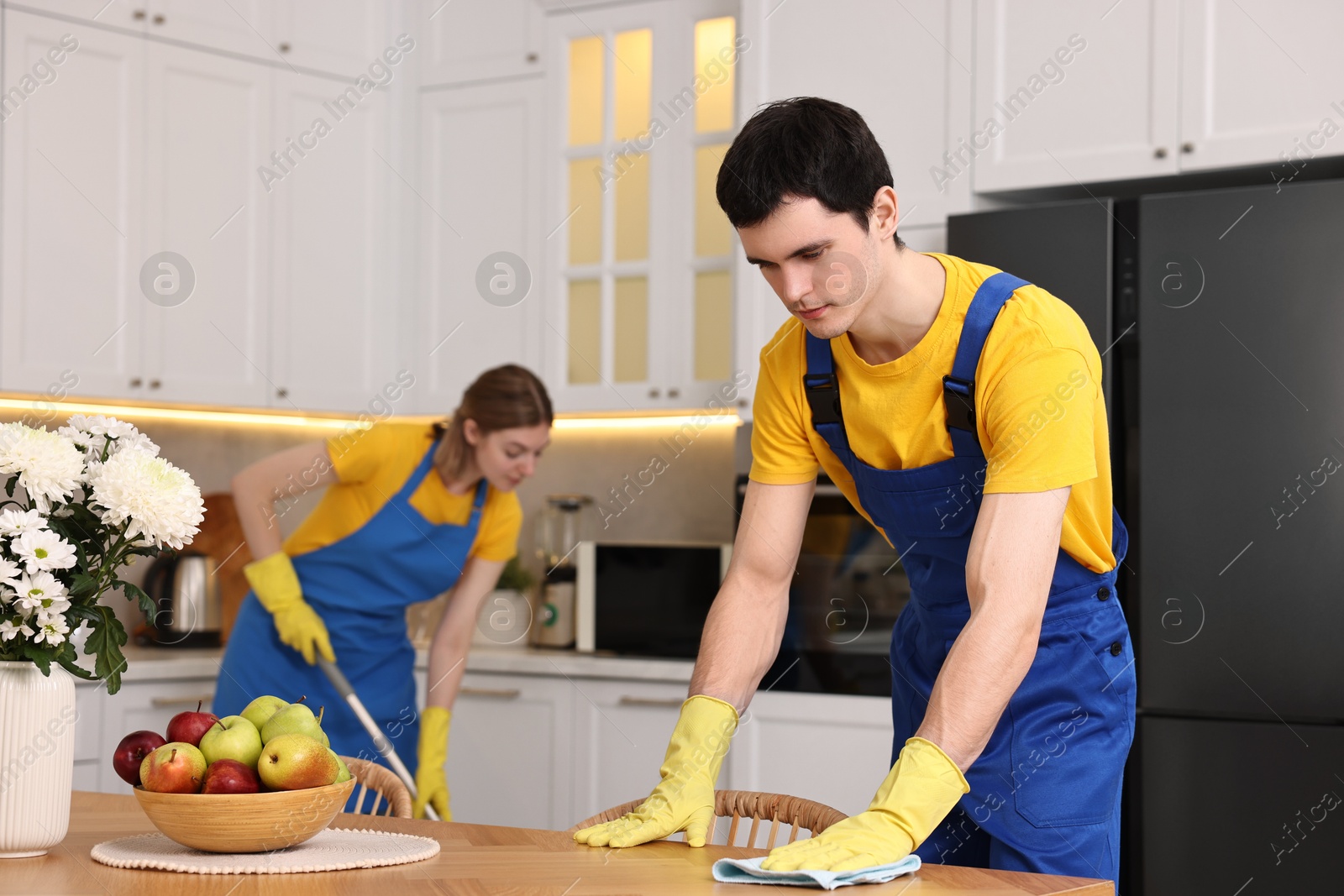 Photo of Professional janitors working in kitchen. Cleaning service