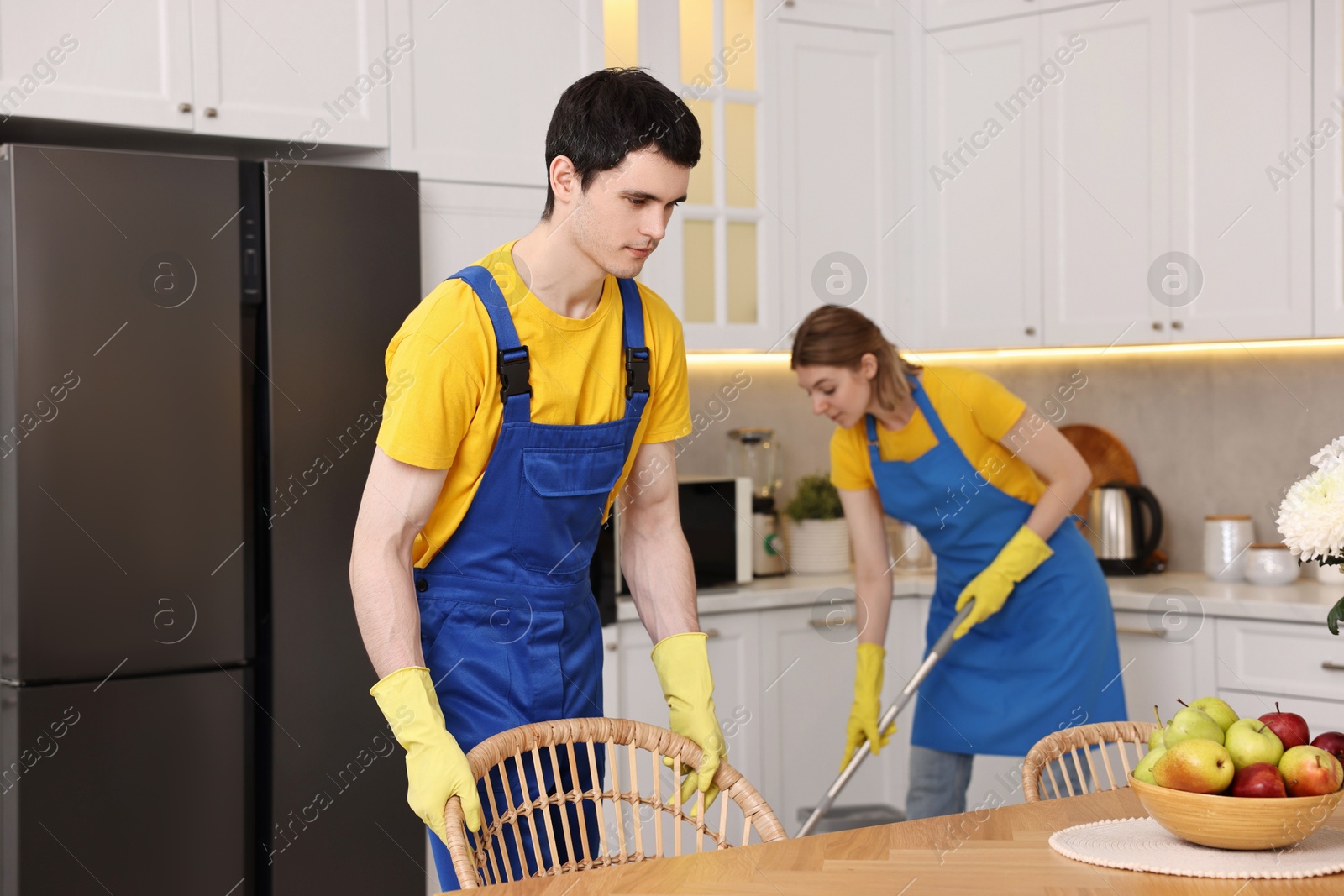 Photo of Professional janitors working in kitchen. Cleaning service